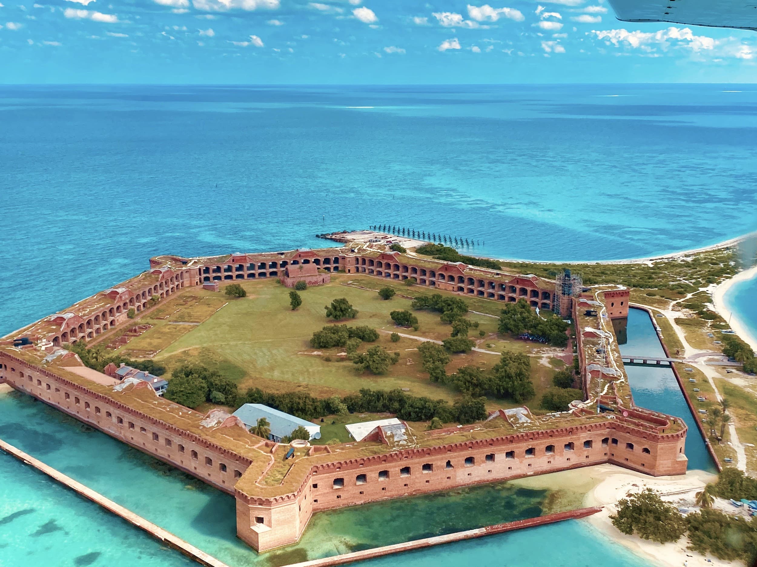 An aerial view of Fort Jefferson in Dry Tortugas National Park, surrounded by clear blue water.