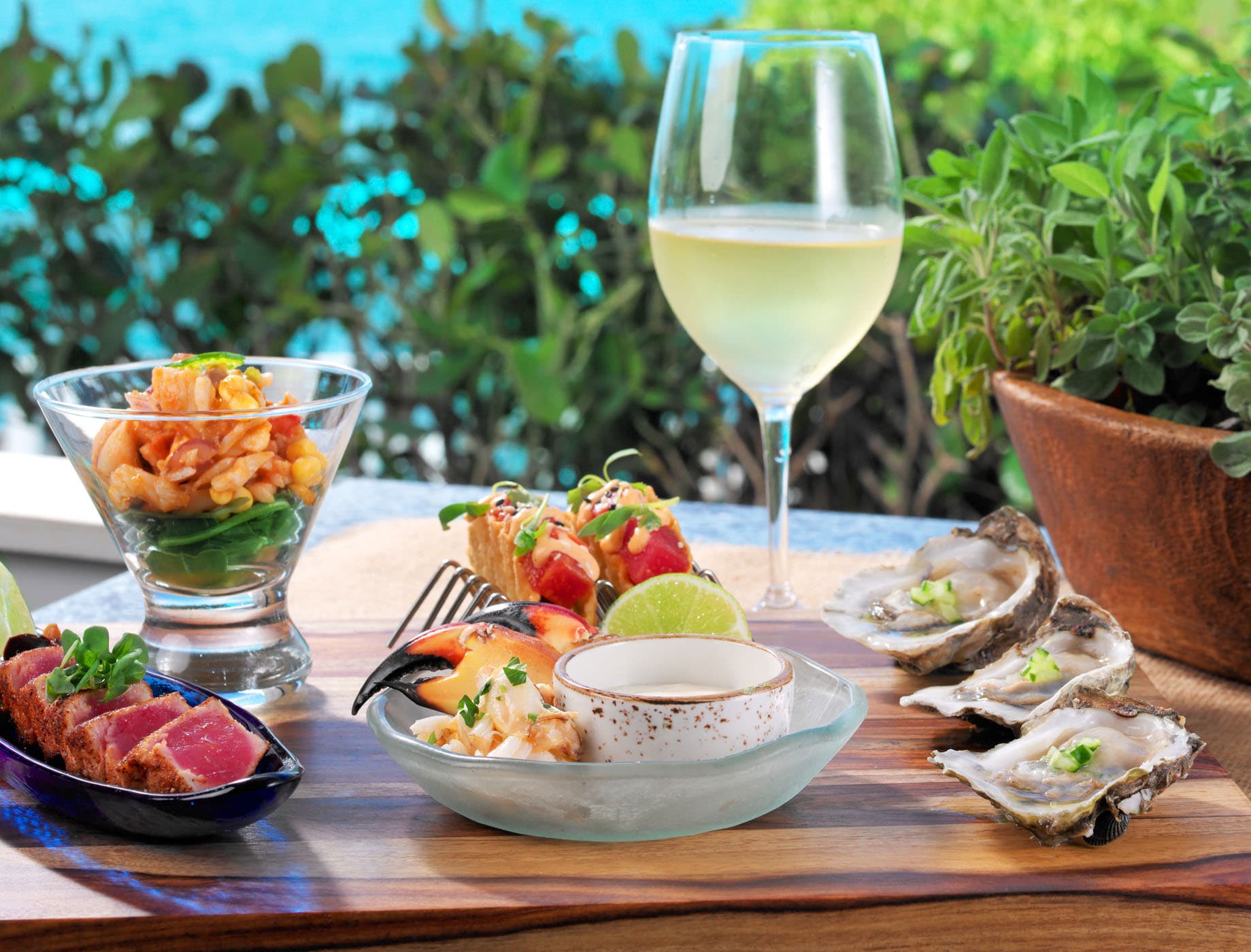 4 seafood dishes and a glass of white wine