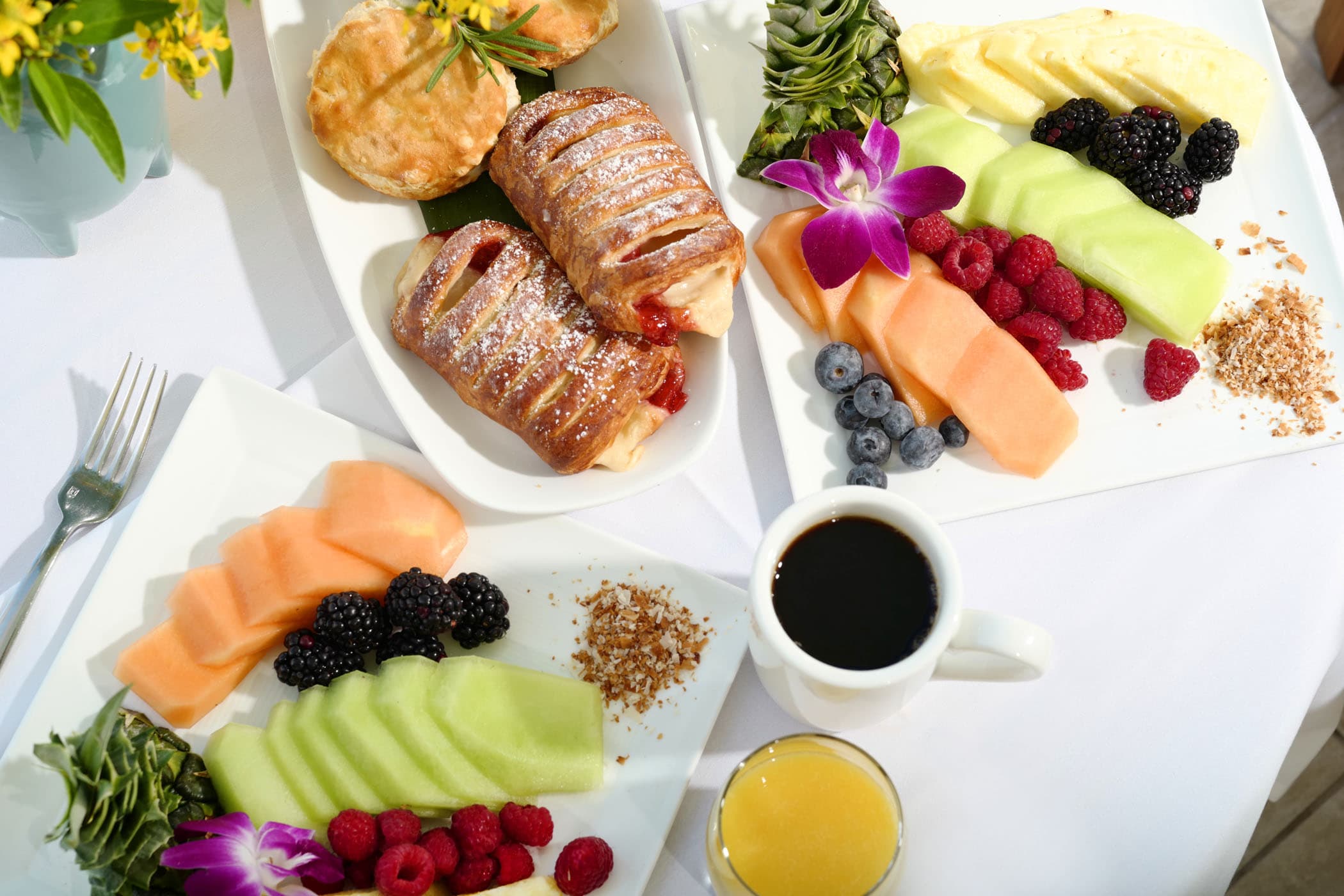 A spread of pastries, fruits and beverages