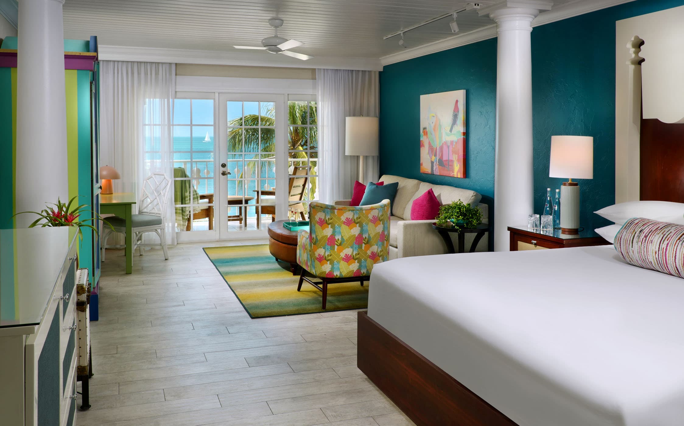 An open concept room with a living space, bed area and a balcony