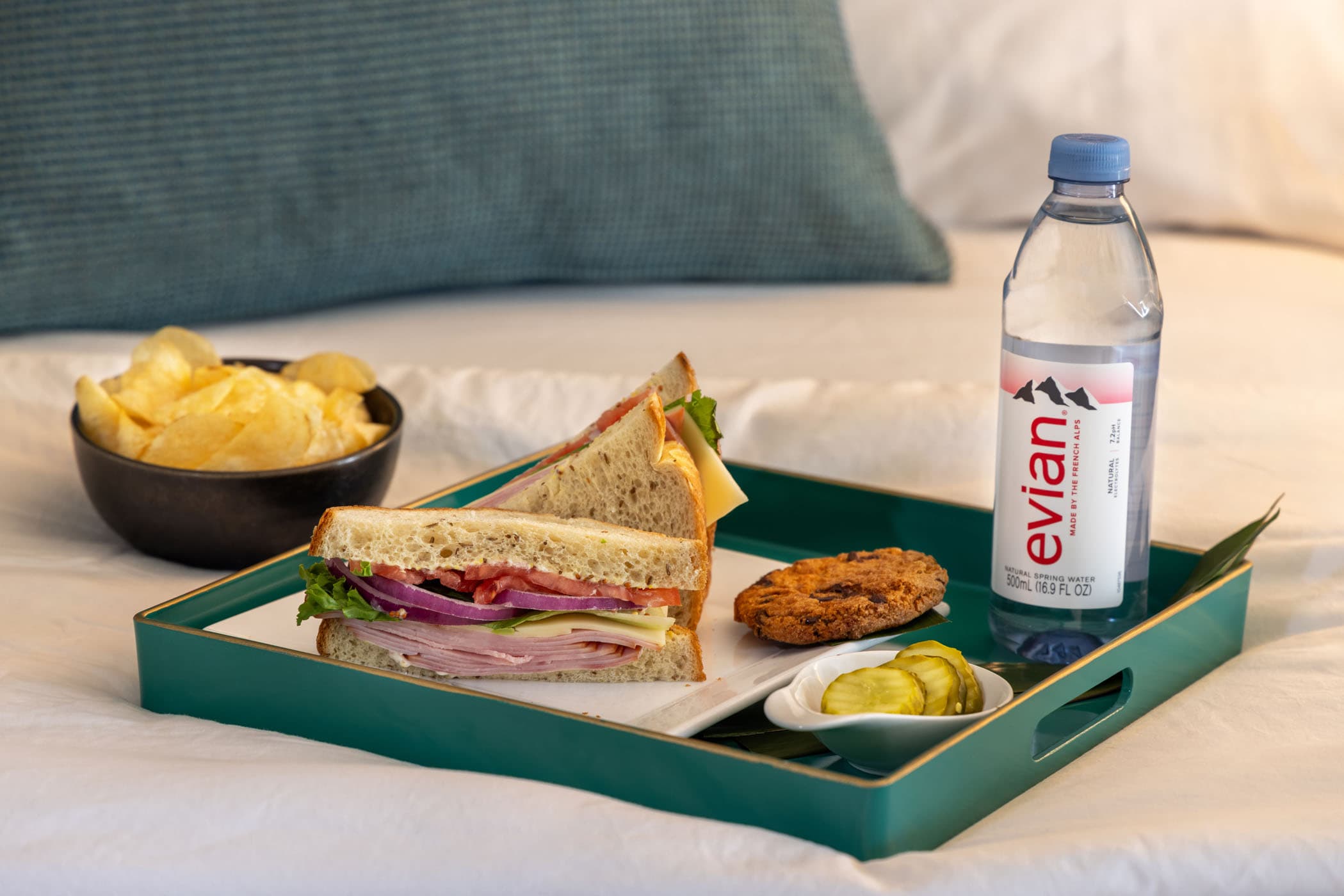 A sandwich, cookie, pickles, chips, and bottle of water on a tray in a room at Ocean Key Resort