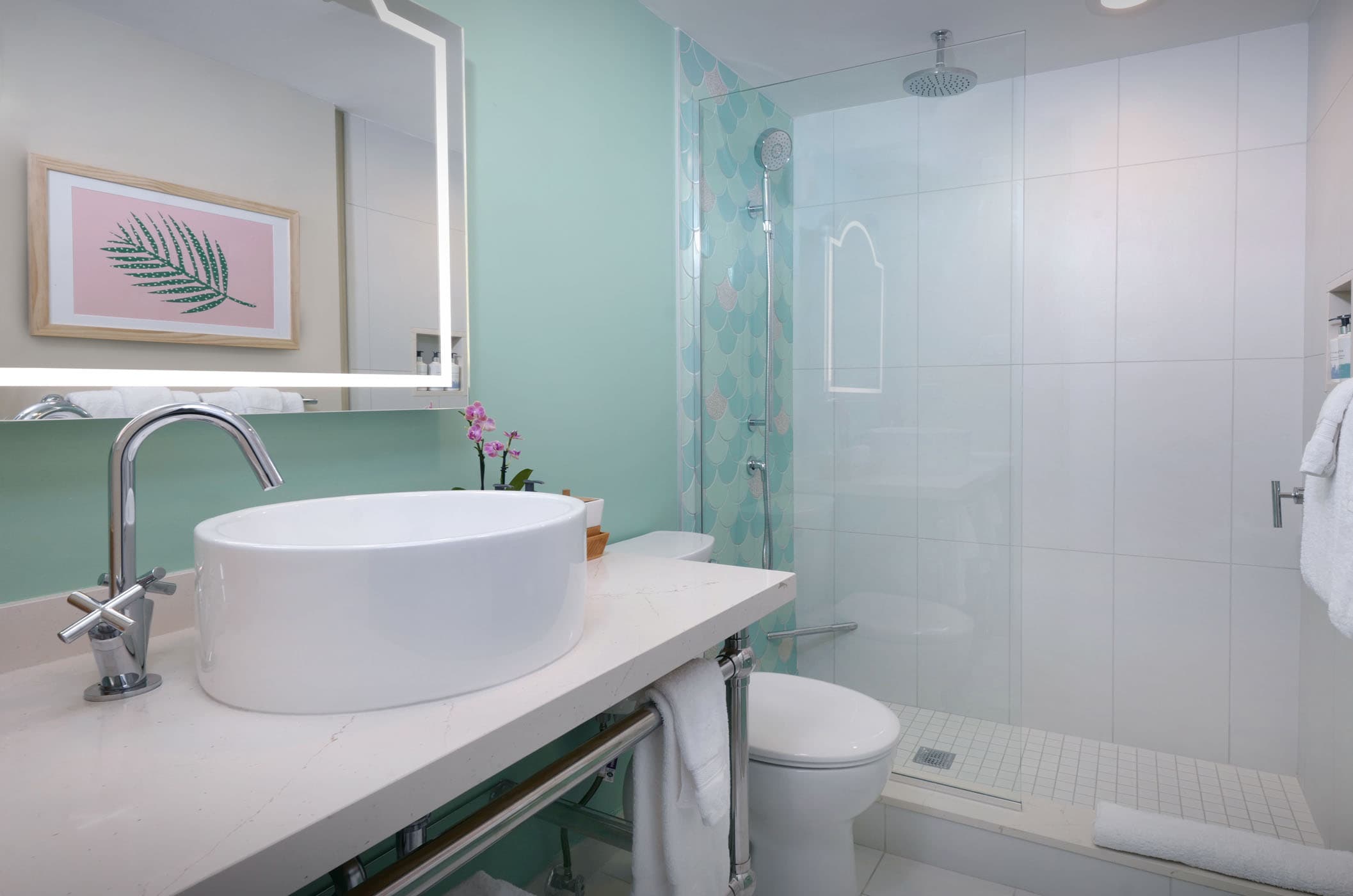 A vanity sink, and shower in a bright washroom at Ocean Key