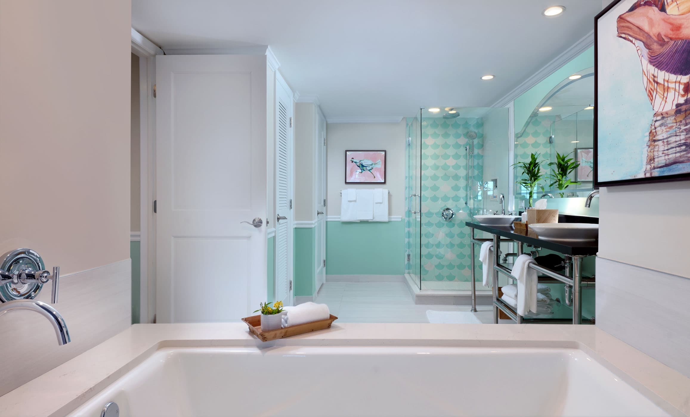 A large washroom with a tub, double sink vanity and glass shower at Ocean Key