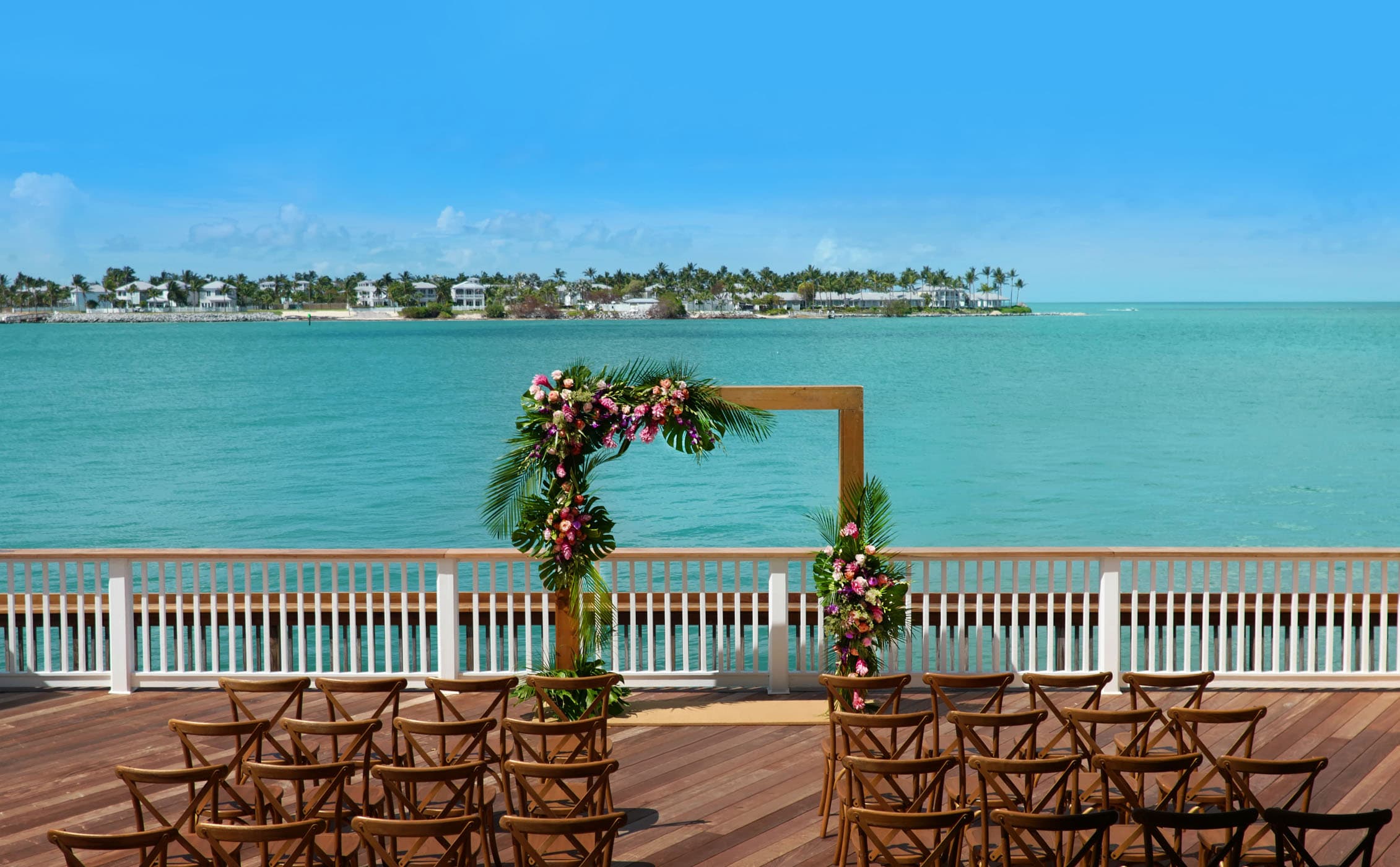 A wedding arch and chairs set up for a wedding on the pier at Ocean Key Resort