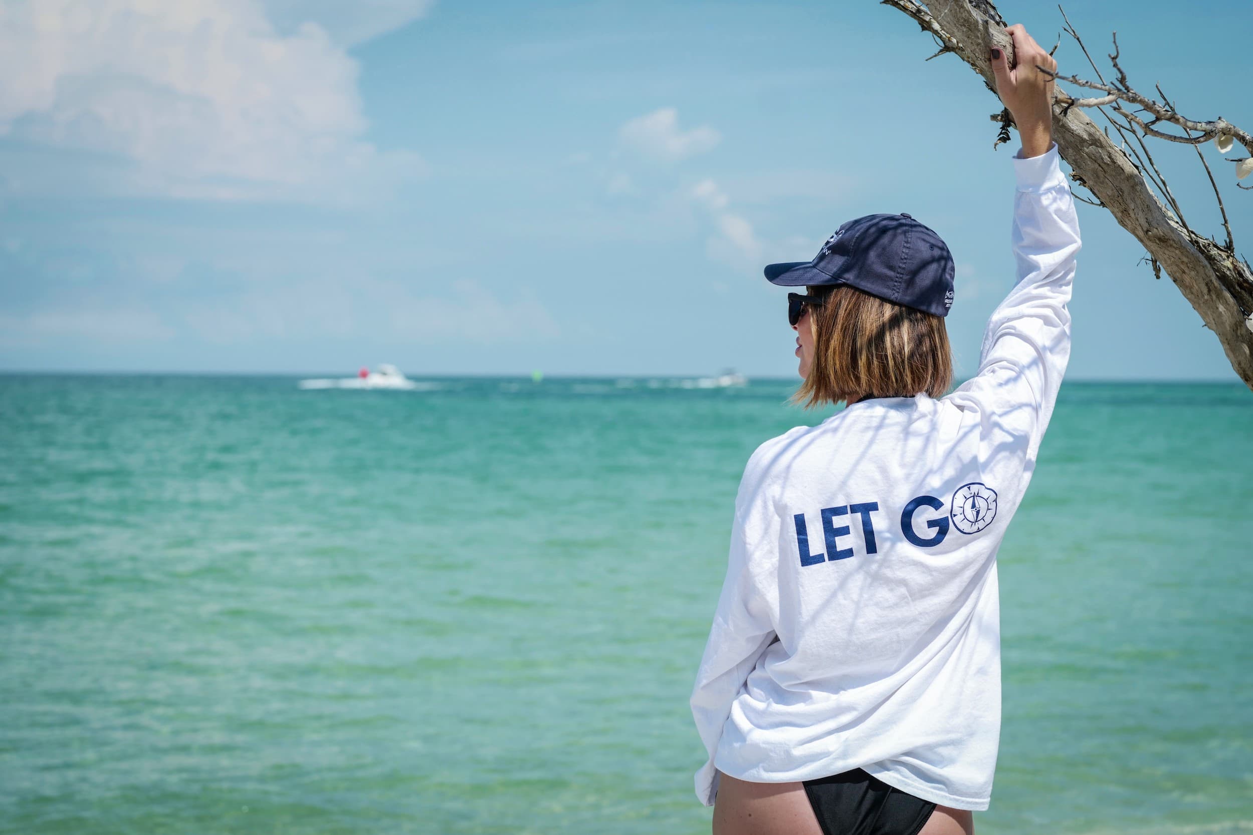 A lifeguard holding a tree branch looking at the water