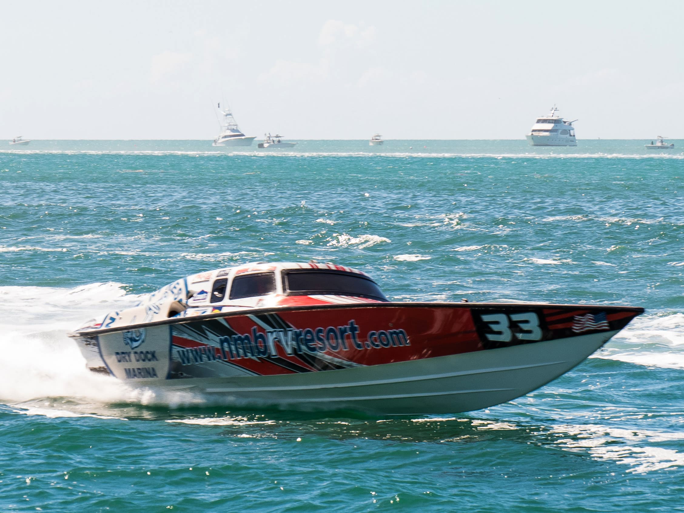 A red and white speed boat in the water during A boat during in the water World Offshore Key West Championships
