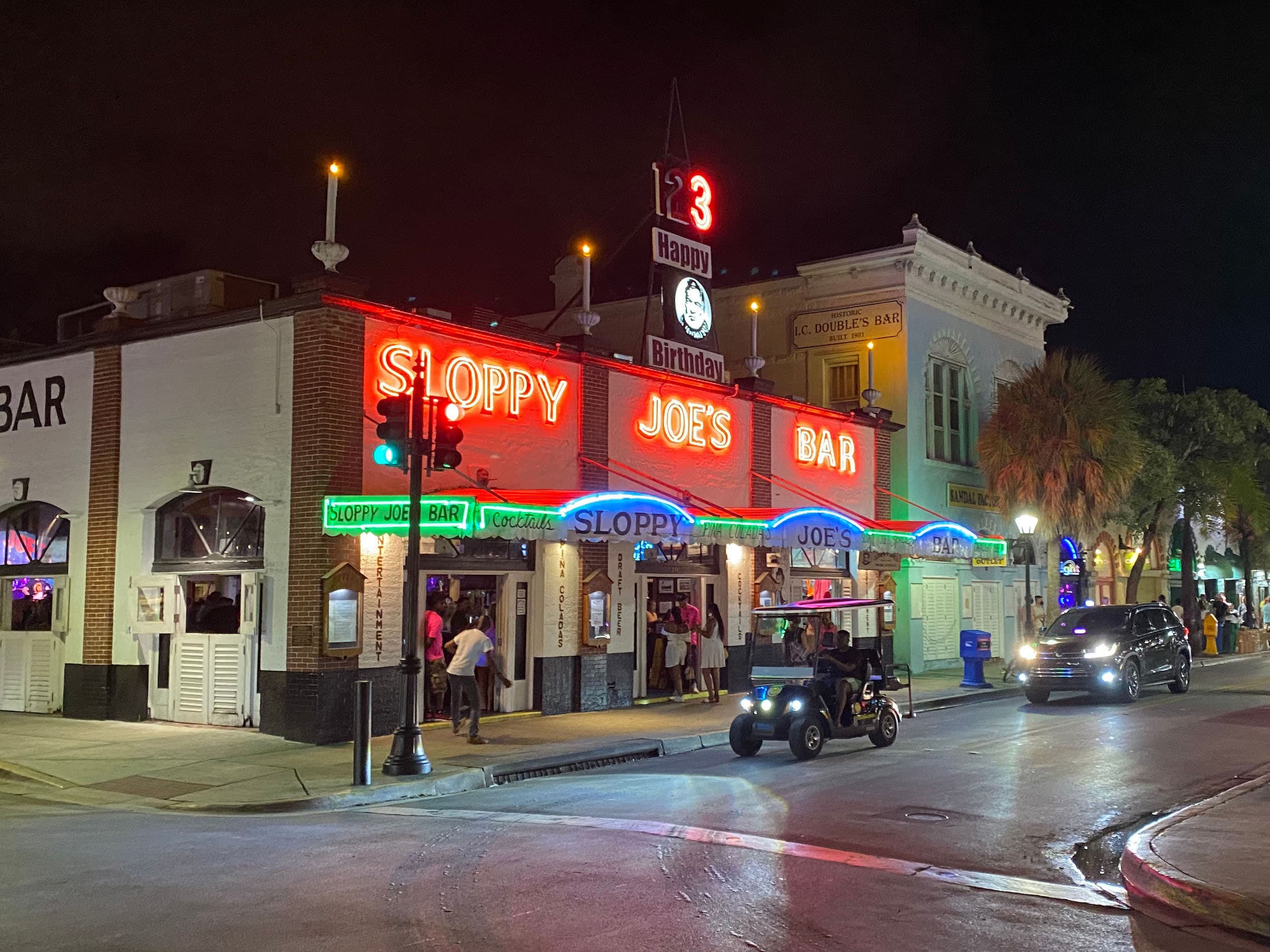 The iconic neon sign of Sloppy Joe’s Bar at night.