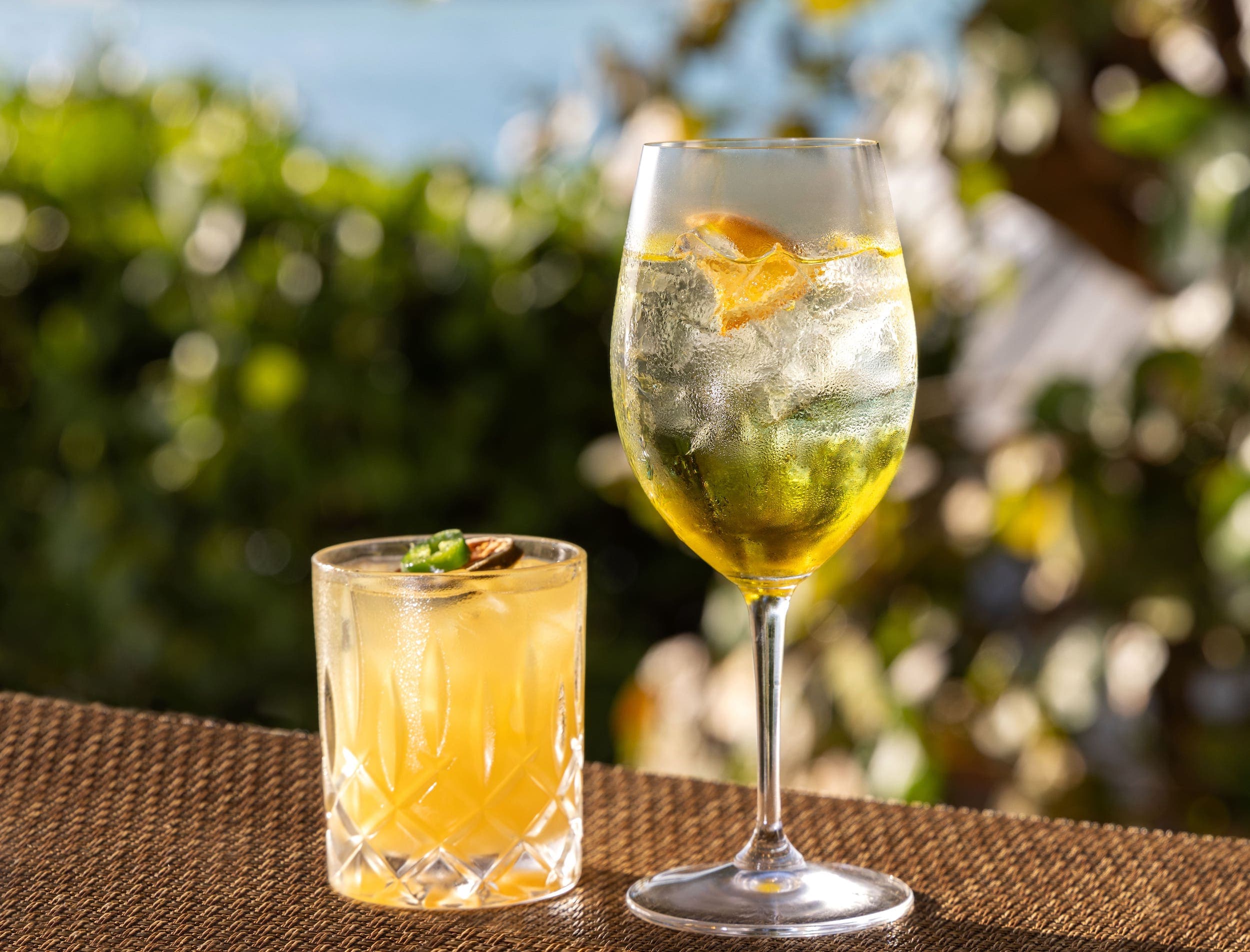 2 yellow cocktails, one in a small rocks glass and one in a wine glass