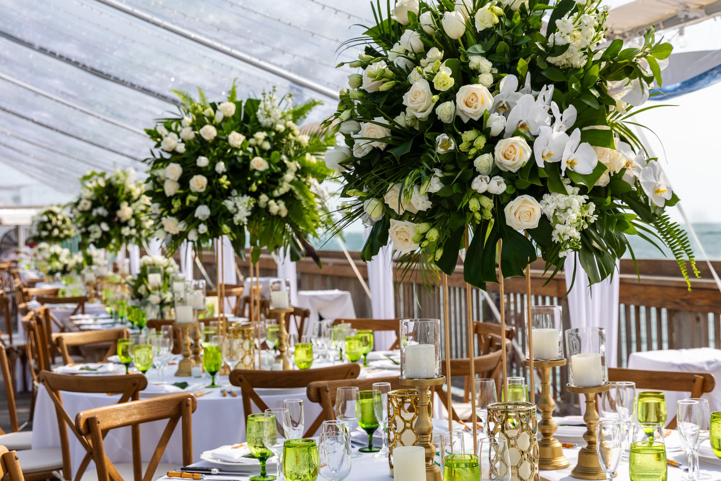A wedding venue decorated with beautiful white and off white flower bouquets hanging above the dinner tables
