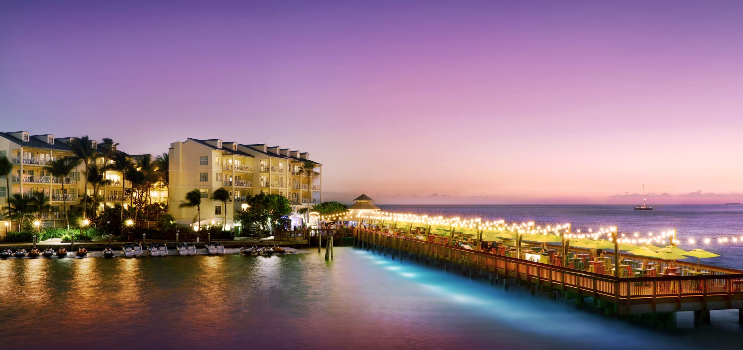 A lit up Sunset Pier at night glowing over the water