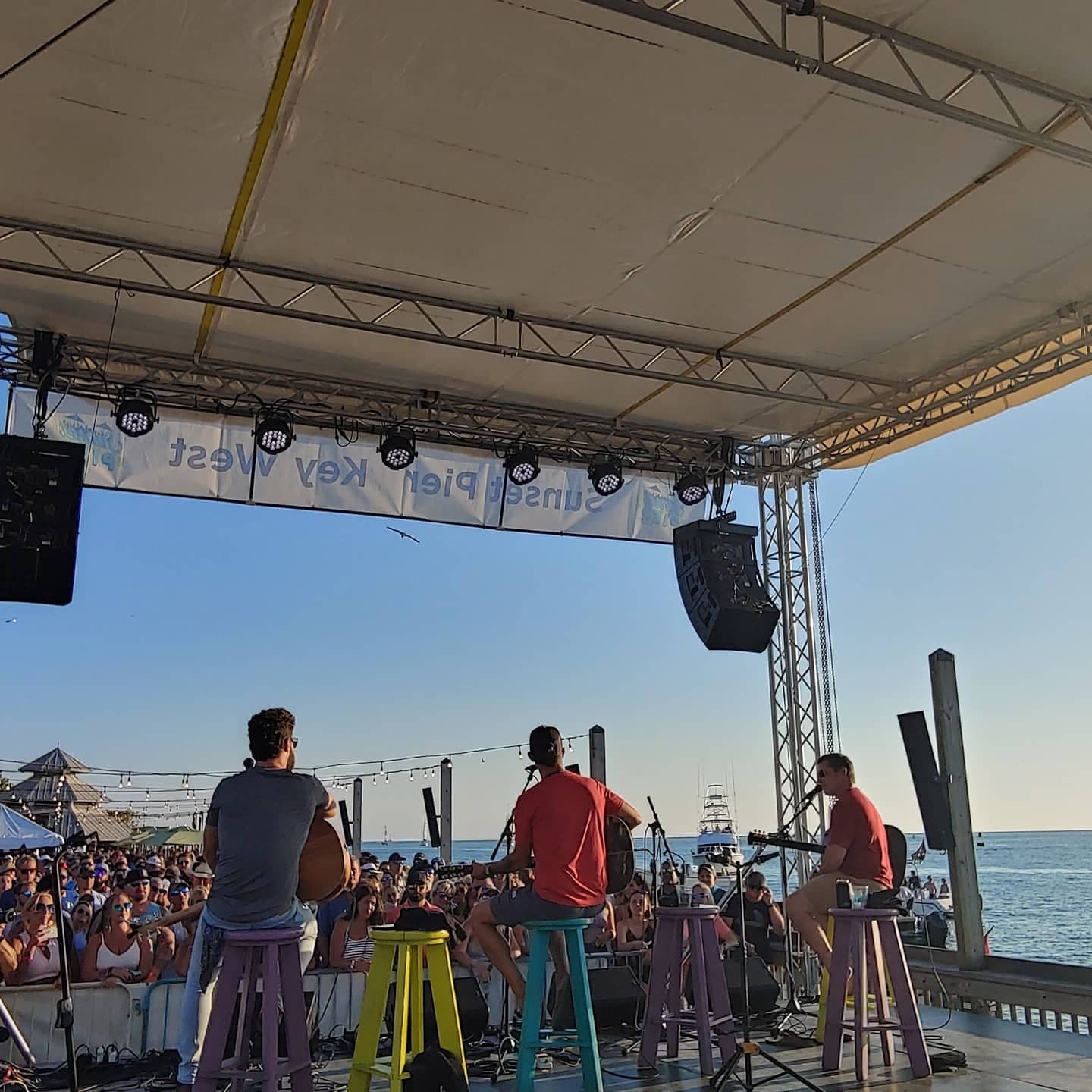 Guitarist performing at dusk for a crowd under string lights at Sunset Pier, Ocean Key Resort, Key West, Florida