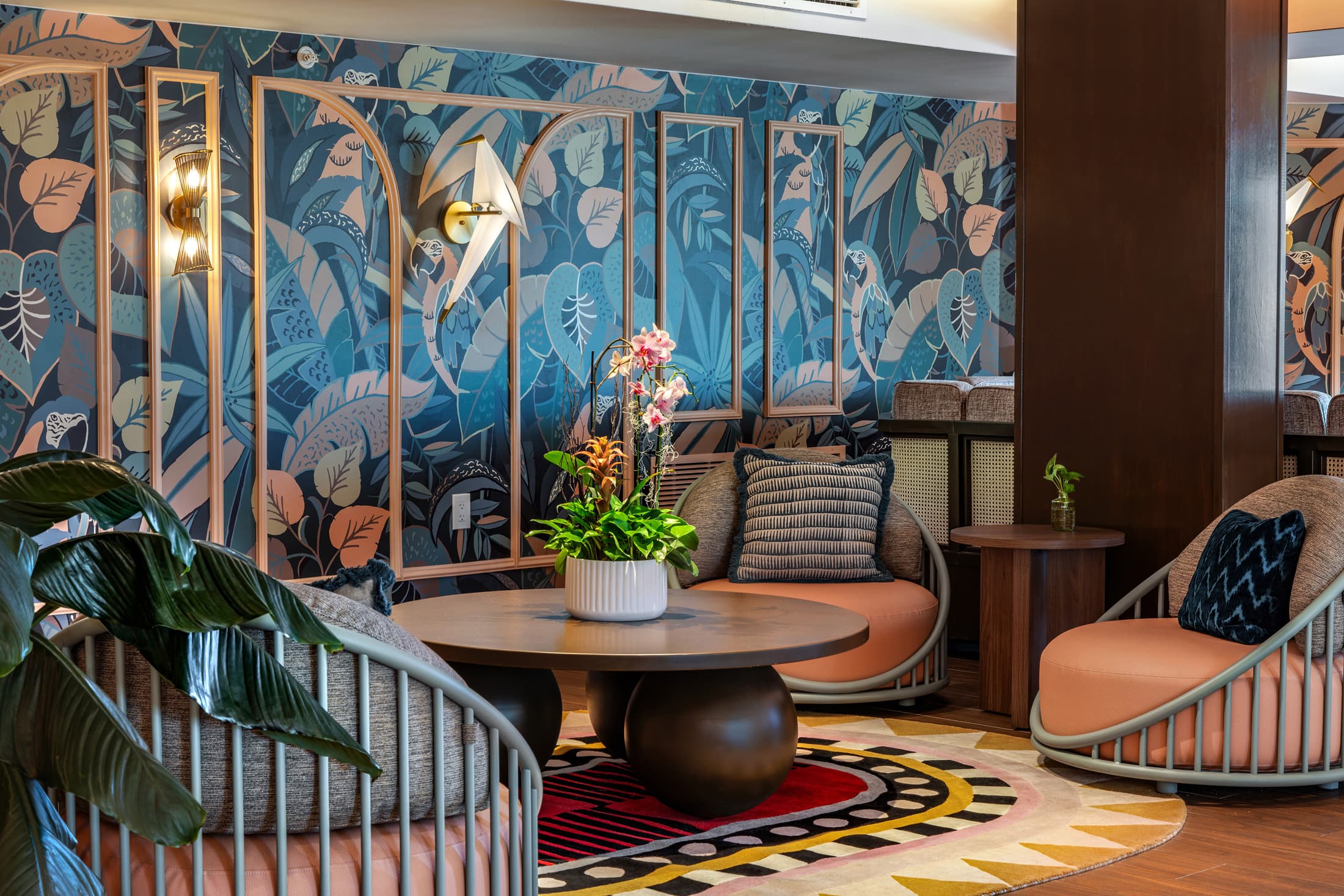 Blue-toned lounge room with artistic mural walls, curved armchair seating, patterned rug, and warm ambient lighting at Ocean Key Resort