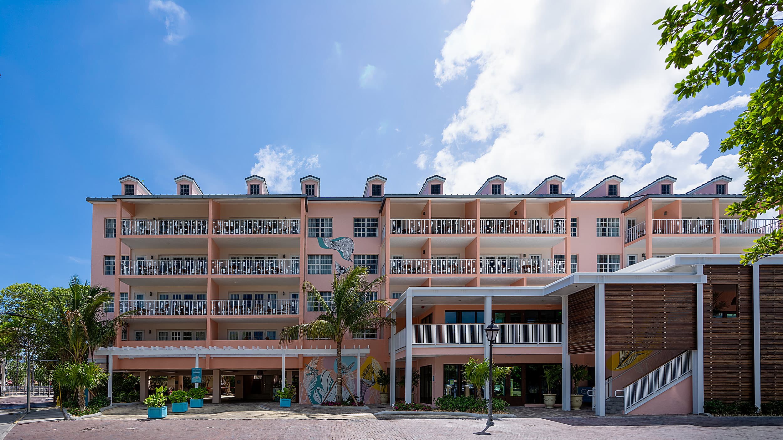 Pastel pink guest room building with balconies and palm trees at Ocean Key Resort in Key West, Florida