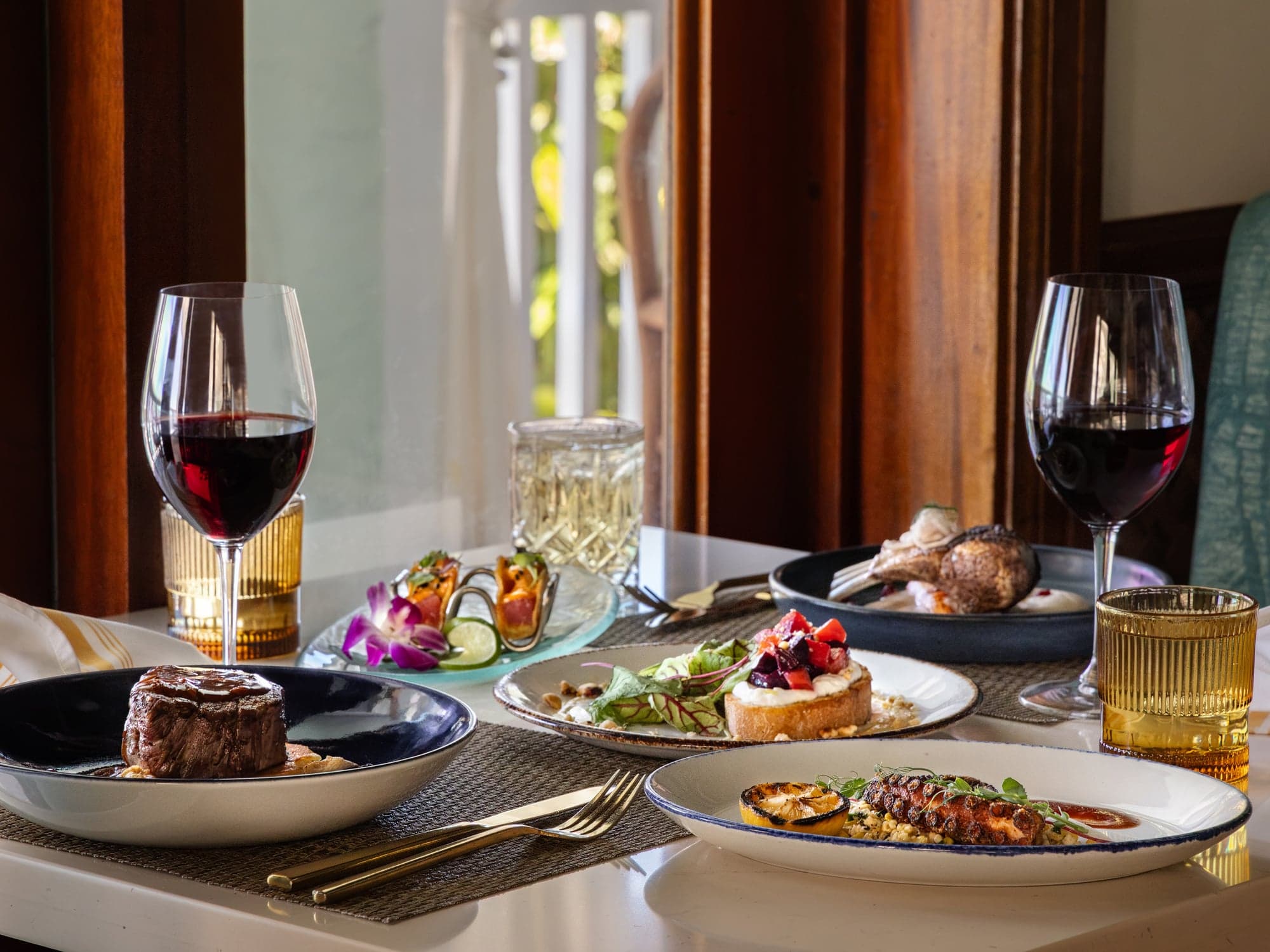 Dinner for two by the window at Hot Tin Roof with filet mignon, grilled octopus, beet toast, and red wine