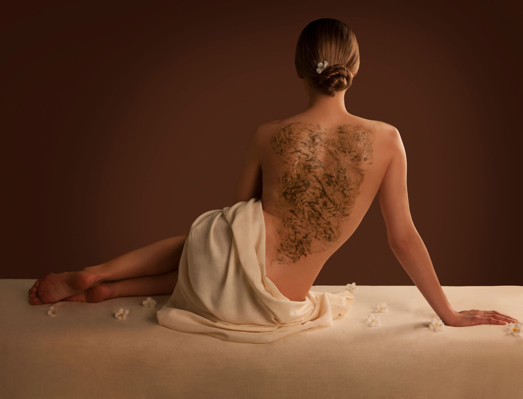 A woman with a mud mask on her back at the spa
