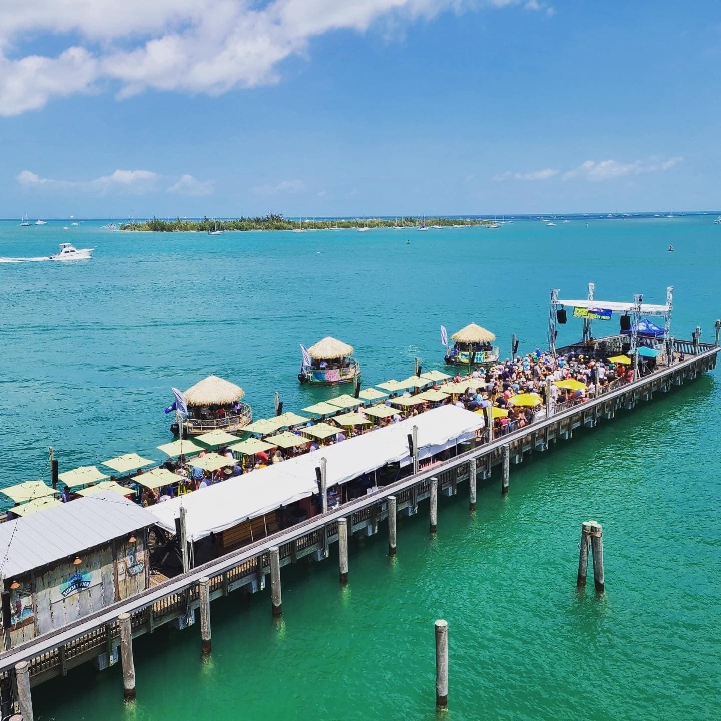 Aerial view of Sunset Pier packed with umbrellas and tiki boats at Ocean Key Resort, Key West, Florida