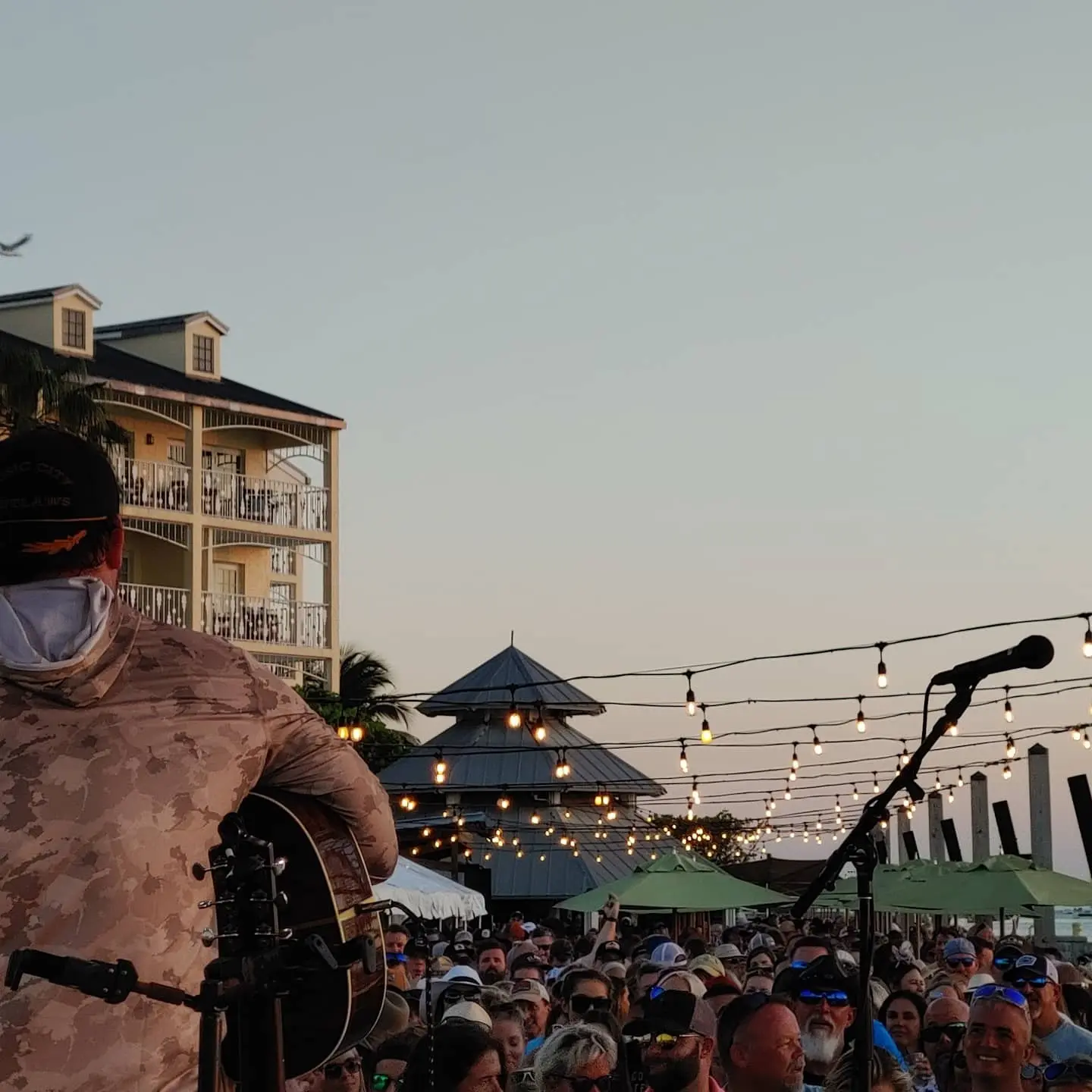 Songwriters performing on stools at the Sunset Pier stage overlooking the ocean at Ocean Key Resort, Key West, Florida