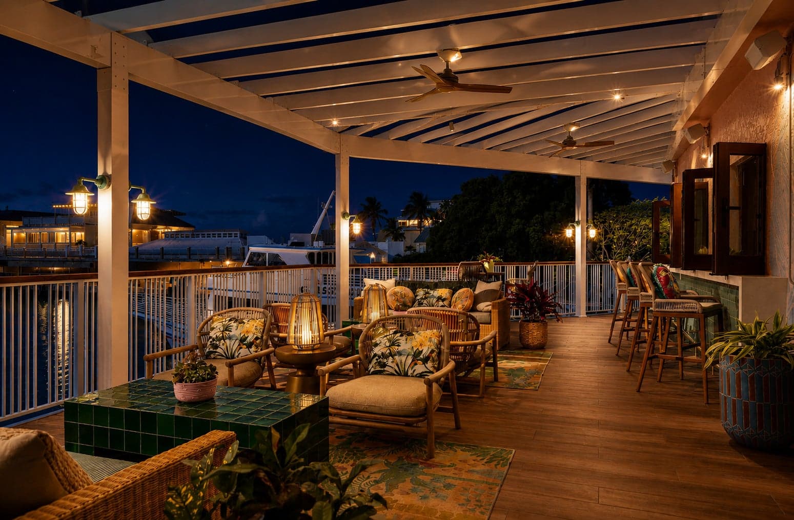 Sweet Bird terrace at night with lantern-lit rattan seating and harbor views, Ocean Key Resort, Key West, Florida