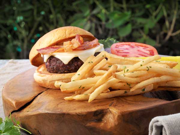 Burger and fries on a table outside.